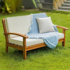 a couch with a blanket on it in the grass