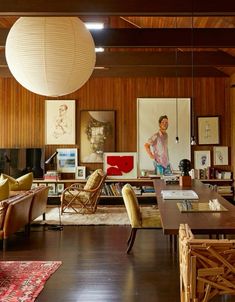 a living room filled with furniture and a large lamp hanging from the ceiling above it