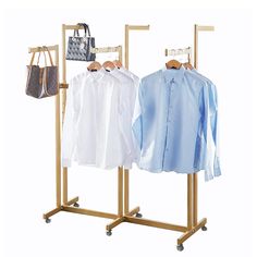 two clothing racks with shirts on them and a handbag hanging from the top rack