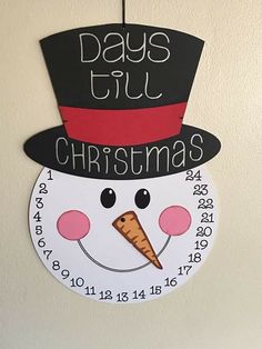 a clock with a snowman wearing a top hat and the words days till christmas written on it