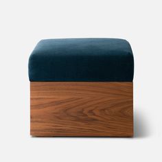 the foot stool is made out of wood and blue velvet