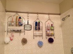 there are several items hanging on the wall above the shower head and in the bathtub