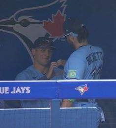 two baseball players are signing autographs for each other