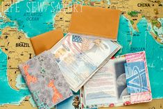 several passport covers are laying on top of a map with the world in the background