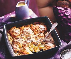 a casserole dish with meat and cheese in it on a purple table cloth