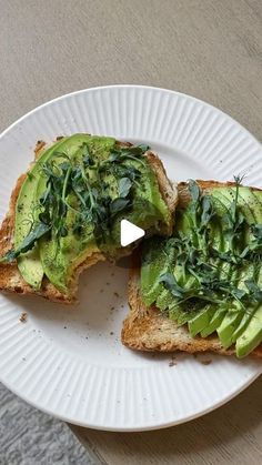 an avocado sandwich is cut in half on a white plate