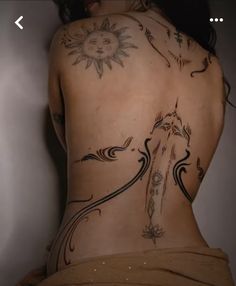 the back of a woman's body with tattoos on it