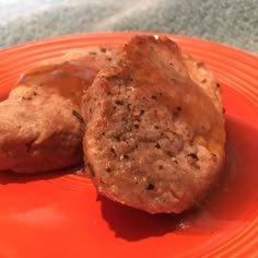 two meat patties sitting on an orange plate