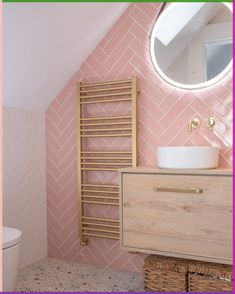 a bathroom with pink and white tiles on the walls, wooden cabinet, toilet and sink