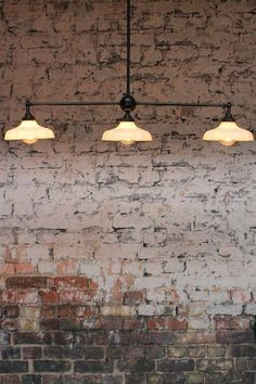 a brick wall with three lights hanging from it