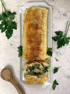 an omelet with spinach and cheese is on a plate next to a spoon