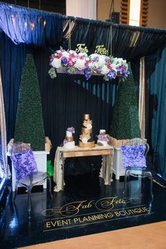 a table with purple and white flowers on it is set up for a wedding reception