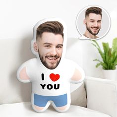 a man with a beard is sitting on a couch and has a pillow that says i love you