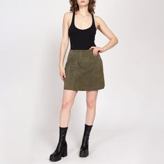 Vintage 90s olive green suede mini skirt, with a high waist. Sold as is with a few condition notes, see details below. Measurements and Condition: Fits like: Labeled size 10, women's medium Fabric: Leather with nylon lining Brand: Kathy Ireland Condition: Fair, with wrinkling to the suede causing it to not lie totally flat, and some faint discolorations (see photos). Length: 17" Waist: 29" Hips: 39" - taken at the bottom of the zipper opening Shown on a 5'8" model with measurements of 35"-26"-38", usually wears a size small to medium. See our FAQ for more info on sizing and condition ratings. High Waisted A Line Skirt, Kathy Ireland, Suede Mini Skirt, Prep School, Line Skirt, Green Suede, A Line Skirt, Label Sizes, A Line Skirts