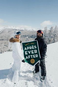 two people standing in the snow holding a sign that says apris - eric apris - eric apris ever after