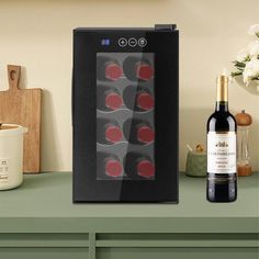 a bottle of wine sitting on top of a green counter next to a glass case