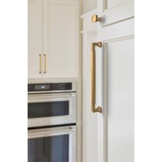 a kitchen with white cabinets and gold handles on the door knobs is pictured in this image