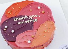 a birthday cake decorated with different colored frosting shapes and saying thank you, universe