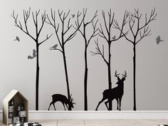 the wall decals are designed to look like trees with deers and birds on them