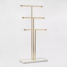 a gold and white stand with three bars on it's sides, in front of a white background