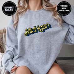 Michigan Football Sweatshirt, Michigan Football Shirt, Ann Arbor Michigan Sweatshirt, College Football Sweatshirt Show off your team spirit with our Michigan Football Sweatshirt, a must-have for any true Wolverines fan! This is not just another generic college sweater, but a unique piece that embodies the spirit of Michigan football and the U of M community. Crafted from premium quality cotton blend, this piece guarantees not only comfort but also durability. Available in a range of sizes from s Relaxed Fit Crew Fan Apparel Tops, Relaxed Fit Crew Neck Fan Apparel Top, Sports Season Crew Top With Team Name, Team Spirit Crew Tops For Sports Season, Cotton Crew Top With Team Name, Athletic Heather Long Sleeve Top For Fans, University Logo Tops For Fan Gear, Relaxed Fit Crew Top For Sports Season, Game Day Crew Top With Team Logo