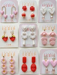 many different types of earrings are displayed on a white card with pink and red flowers