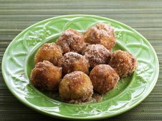 a green plate topped with sugar covered donuts