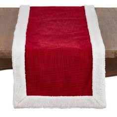 a red and white table runner sitting on top of a wooden table