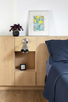 a bedroom with a bed, night stand and nightstand in the corner next to it