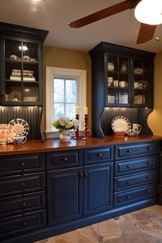 an image of a kitchen with black cabinets and wood counter tops on the bottom shelf