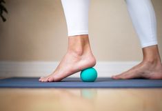 a person standing on top of a blue yoga mat