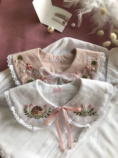 three white blouses with embroidered flowers on them