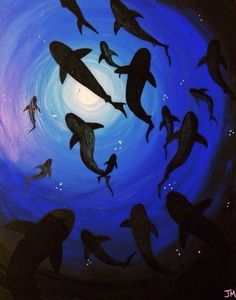 a group of dolphins swimming in the ocean at night with bright blue light coming from behind them