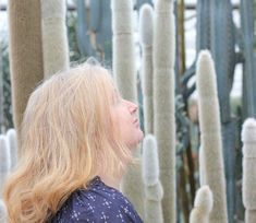 a woman standing in front of many cacti