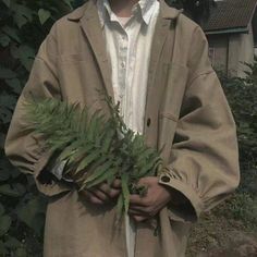 a man holding a plant in his hands