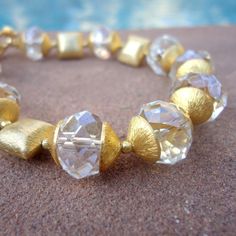 This crystal bracelet created by Jewelry by Carmal is made of: -Clear faceted rondelle crystals -24K gold vermeil bead caps -24K gold vermeil square beads -24K gold vermeil quatrefoil charm -14K gold filled beads -14K gold filled findings -14K gold filled toggle closure This clear crystal and gold bracelet measures 8 1/4 inches in length. The charm measures an additional 1/2 inch in length. View more beaded bracelets: http://www.etsy.com/shop/jewelrybycarmal?section_id=8002918 WE OFFER FREE STAN Fancy Ice, Clear Crystal Bracelet, Jewellery Unique, Square Beads, Bracelet Wedding, Square Bead, Crystal Bracelet, Bead Caps, Wedding Bracelet