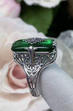 Emerald Green Stone Glass & CZ Ring Grace Design#233 Custom Made I now offer this lovely Antique Art Deco/Edwardian design ring in sterling silver. This gorgeous ring is set with a stunning floral filigree embellished deep emerald green glass/resin with a centered set 1mm white Cubic Zirconia (CZ). The emerald color glass/stone is 18mm Long by 19mm Wide. The ring sits 19mm North South on the finger and 10mm East West on the finger. The inside of the band is marked 925 for sterling. Notice th Polished May Birthstone Jewelry For Weddings, Silver Art Deco Emerald Wedding Ring, Art Deco Silver Emerald Wedding Ring, Elegant Silver Emerald Ring Collectible, Green Sterling Silver Art Deco Jewelry, Formal Sterling Silver Filigree Ring With Stone Setting, Art Deco Green Jewelry With Accent Stones, Green Art Deco Jewelry With Accent Stones, Victorian Sterling Silver Jewelry With Accent Stones