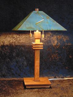 a wooden table lamp sitting on top of a counter next to a blue shade covering