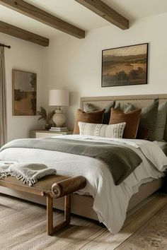 a large bed sitting in a bedroom on top of a hard wood floor next to a window