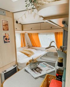 the interior of a small camper with orange curtains