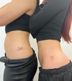 two women with tattoos on their stomachs, one has a bow in her pocket