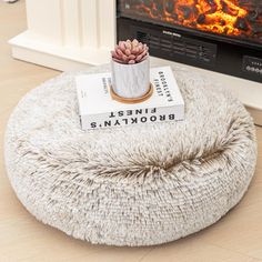 a white bean bag sitting on top of a wooden floor next to a fire place