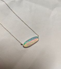 A pendant that is eye-catching and wonderfully unique. A mesmerizing shade of opal in a modern setting of 925 Sterling Silver, 18K gold polished. This pendant will bring gravitas to your everyday wear. Thanks for stopping by! Happy Shopping! H O W ~ T O ~ O R D E R  It's easy as 1, 2, 3! 1. Select options from the dropdown menu  2. Add to cart and proceed to checkout. C A R E ~ T I P S We don't want your special moment to fade. To maintain the quality of your new Misha Jewels jewellery, please: - Do not wear it to the pool, spa, or the beach  - Remove when sleeping, exercising, or doing other physically strenuous activities - Avoid contact with perfumes, body oils, and other chemicals, including household cleaners. - Do not use chemical jewelry cleaners - Gently polish with a soft, lint-fr White Gold Opal Necklace For Gift, White Gold Opal Necklace As Gift, Iridescent Gemstone Necklace In Sterling Silver, Iridescent Oval Sterling Silver Jewelry, Elegant Silver Jewelry With Pink Opal, Opal Jewelry With Polished Finish For Gift, Iridescent Opal Necklaces For Gift, Oval Pink Opal Jewelry Gift, Oval Pink Opal Jewelry For Gifts