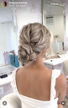 the back of a woman's head with her hair in a low bun braid