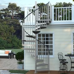 a spiral staircase in front of a house with patio furniture and outdoor dining table set