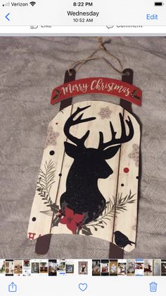 a wooden sign with a deer on it and merry christmas written across the front in red