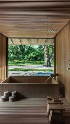 the inside of a room with wooden walls and flooring, including an open air bathtub