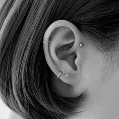 a close up of a person wearing an ear with two piercings on their ears