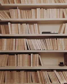 a bookshelf filled with lots of books on top of wooden shelves