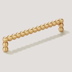 a gold beaded drawer handle on a white background